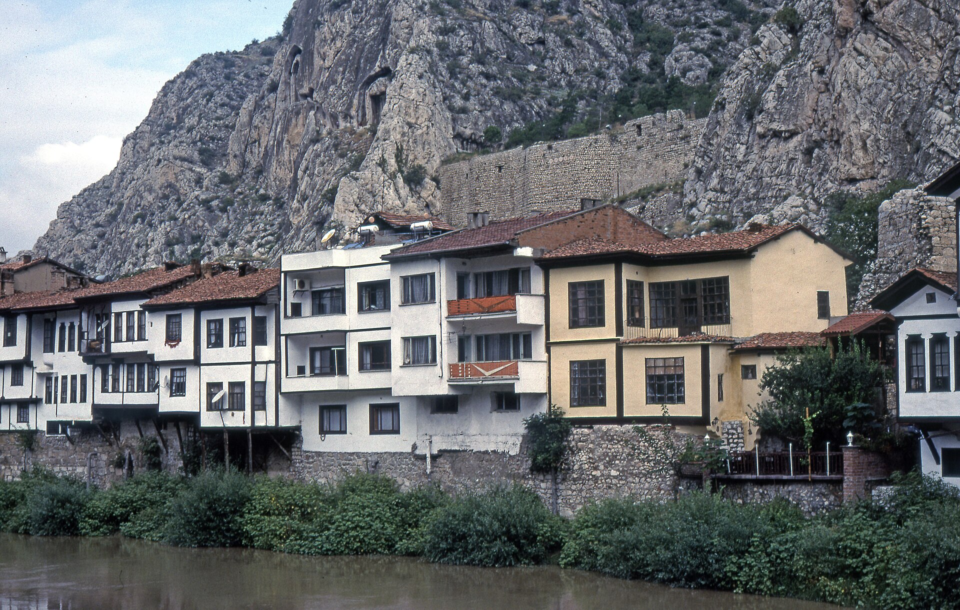 Multi-storey Yalıboyu houses lining the Yeşilırmak at the rocky foot of Mount Harşena